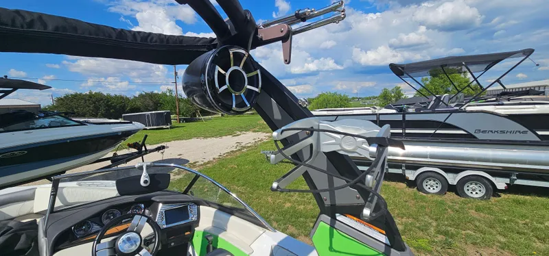 Slide: The Image of 2017 Tigé Z3 boat interior with speaker and steering wheel, parked outdoors under blue sky. - 16