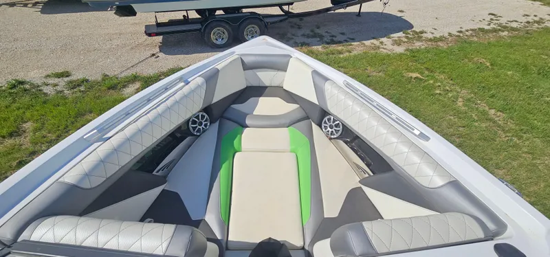 Slide: The Image of 2017 Tigé Z3 boat interior with gray and green seating, featuring speakers and a trailer in the background. - 17