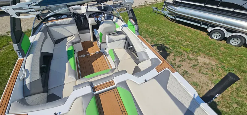 Slide: The Image of 2017 Tigé Z3 boat interior with green and white seating, wood accents, and steering console. - 19