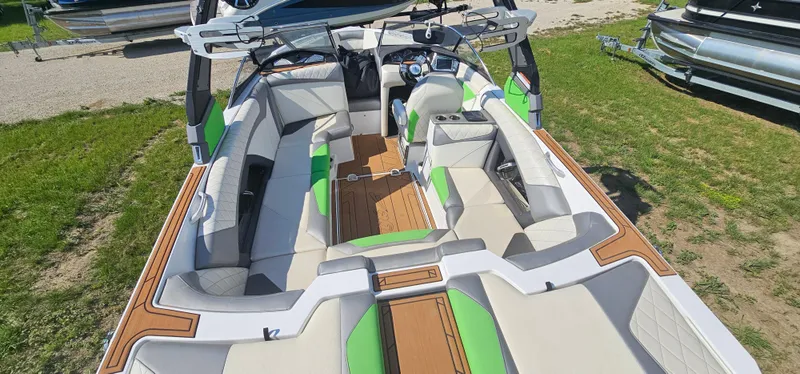 Slide: The Image of 2017 Tigé Z3 boat interior with green and beige seating, wood accents, and modern design. - 20