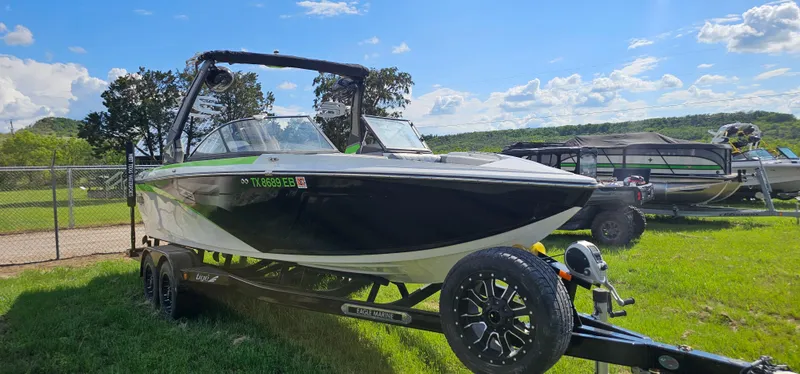 Slide: The Image of 2017 Tigé Z3 boat on trailer in grassy area under blue sky. - 3