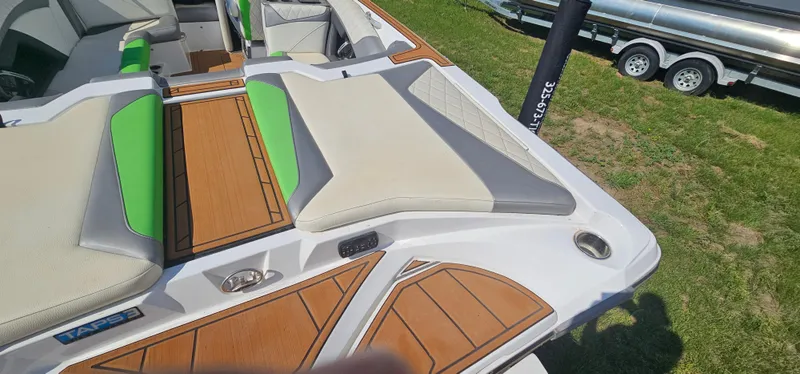 Slide: The Image of 2017 Tigé Z3 boat with green and beige seating, wood accents, parked on grass. - 7