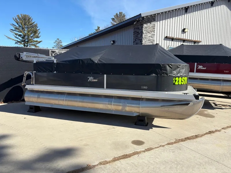 Slide: The Image of 2025 Custom Pontoon Maui boat covered, parked outdoors near a building. - 14