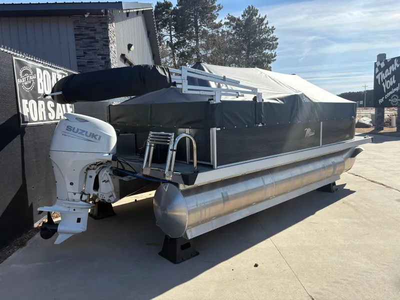 Slide: The Image of Custom 2025 Pontoon Maui with Suzuki engine, covered and displayed outdoors. - 3