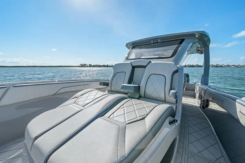 Slide: The Image of 2025 Deep Impact 369 Sport boat interior with luxurious seating on a sunny day. - 15