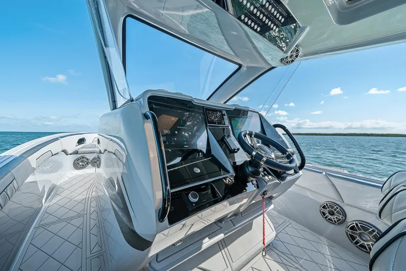 Slide: The Image of 2025 Deep Impact 369 Sport boat cockpit with modern controls and ocean view. - 36