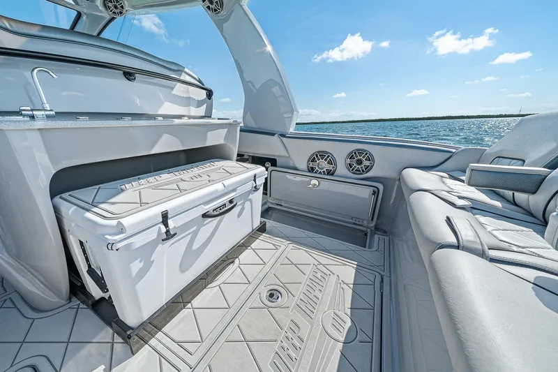 Slide: The Image of 2025 Deep Impact 369 Sport boat interior with seating, cooler, and ocean view. - 40