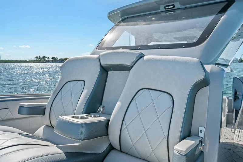 Slide: The Image of 2025 Deep Impact 369 Sport boat interior with luxurious seating and ocean view. - 9