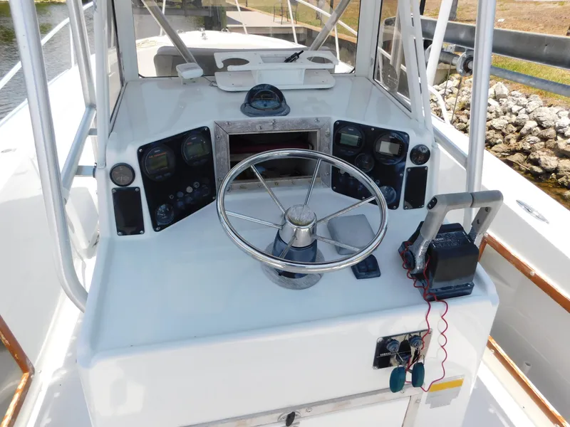 Slide: The Image of 1985 Mako 254 Center Console boat dashboard with steering wheel and controls. - 9