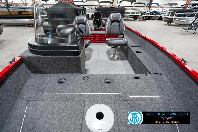 Slide: The Image of 2021 Lund 1650 ANG SS boat interior with seating and console, displayed in showroom. - 16