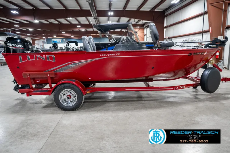 Slide: The Image of 2021 Lund 1650 ANG SS boat in a showroom, red color, on a trailer. - 5