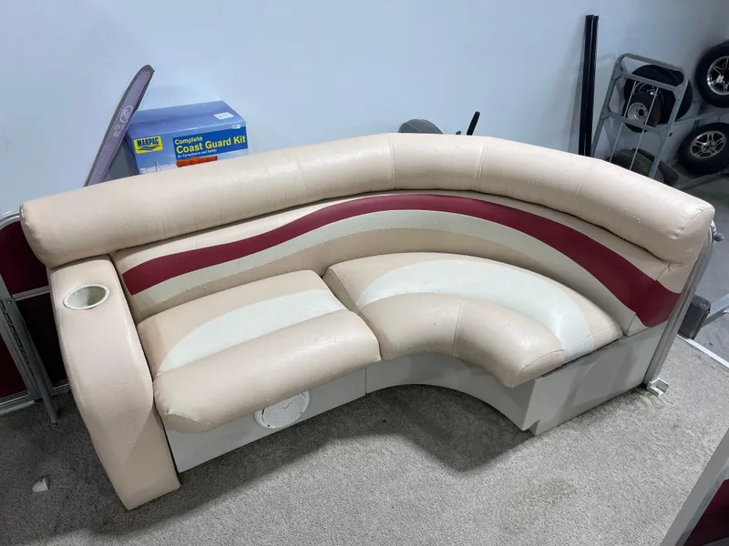 Slide: The Image of 2010 South Bay 520CR boat seating with beige and red upholstery, cup holder, and storage. - 14