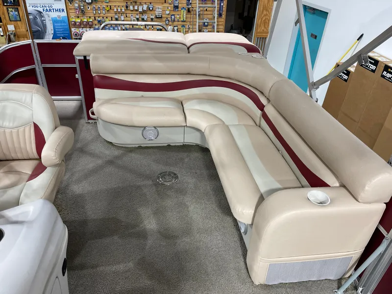 Slide: The Image of 2010 South Bay 520CR pontoon boat interior with beige and red seating. - 15
