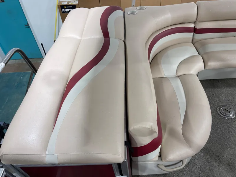 Slide: The Image of Beige and red seating on a 2010 South Bay 520CR boat, featuring cup holders. - 23