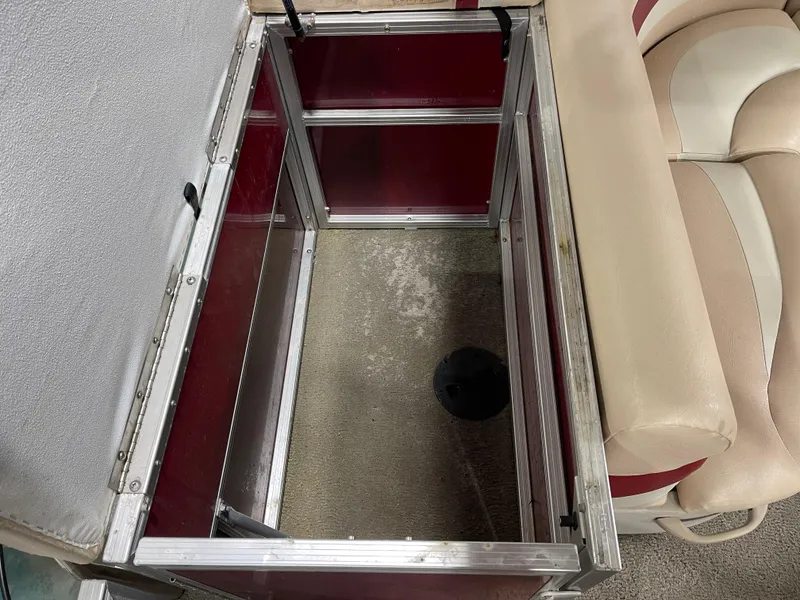 Slide: The Image of Open storage compartment in 2010 South Bay 520CR boat, featuring red and beige interior. - 24