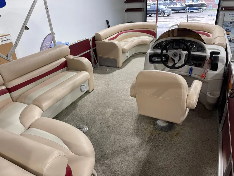 Slide: The Image of Interior of a 2010 South Bay 520CR pontoon boat with beige and red seating. - 26