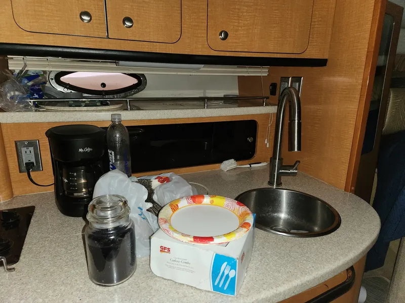 Slide: The Image of 2005 Chaparral Signature 350 kitchen area with sink, coffee maker, and paper plates. - 6