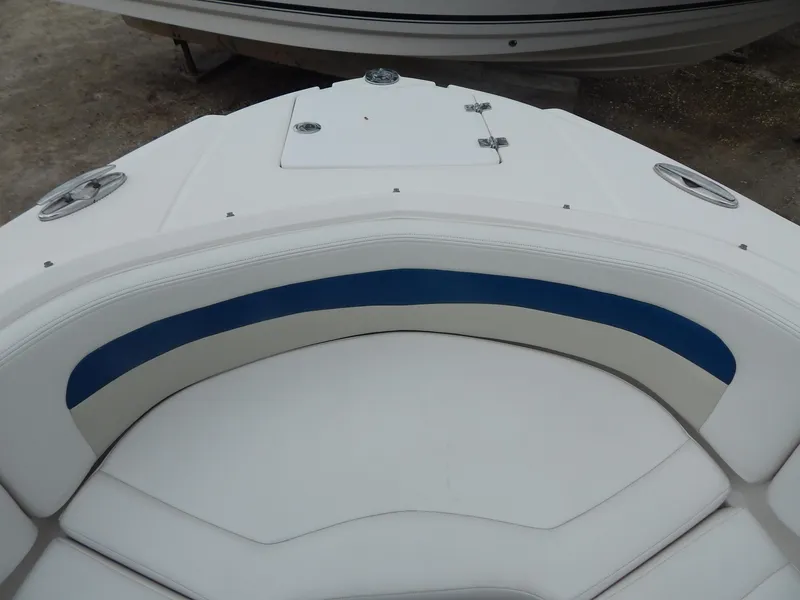 Slide: The Image of Bow seating area of 2016 Chaparral 246 SSi boat with white and blue upholstery. - 10