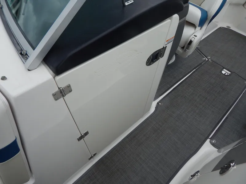 Slide: The Image of 2016 Chaparral 246 SSi boat interior, featuring seating and a closed compartment door. - 17