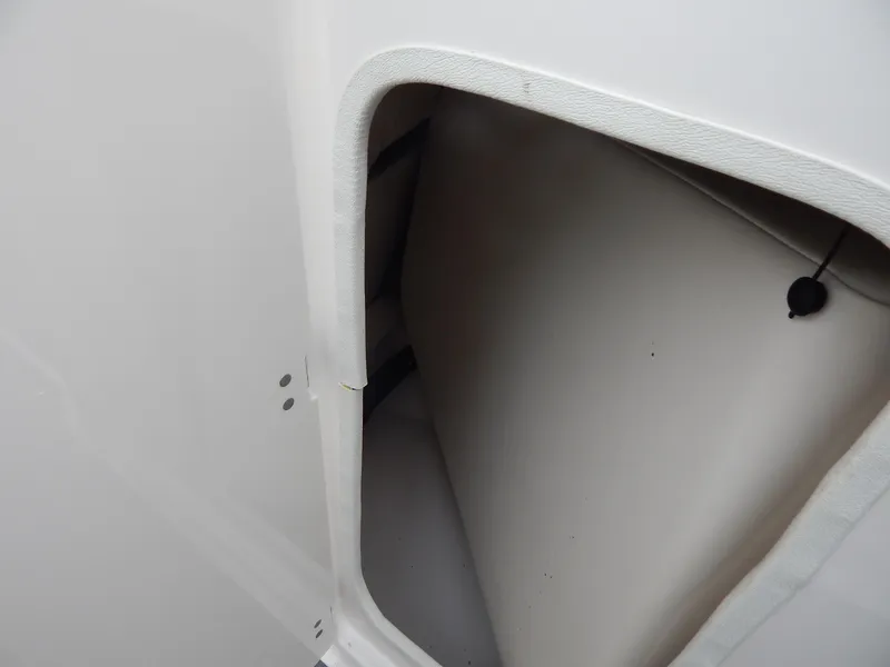 Slide: The Image of Storage compartment on a 2016 Chaparral 246 SSi boat, featuring a white interior. - 18