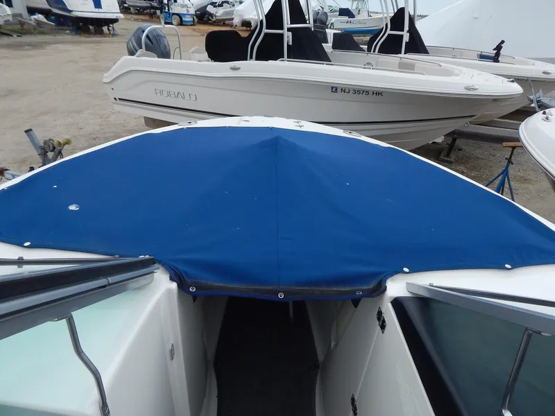 Slide: The Image of Chaparral 246 SSi 2016 boat with blue cover, docked alongside other boats. - 46