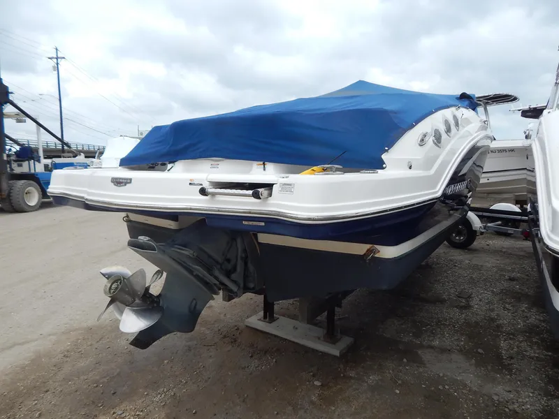 Slide: The Image of 2016 Chaparral 246 SSi boat with blue cover, parked on gravel. - 5