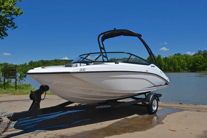 Slide: The Image of 2023 Yamaha Boats AR190 on trailer by a lake under clear blue sky. - 10