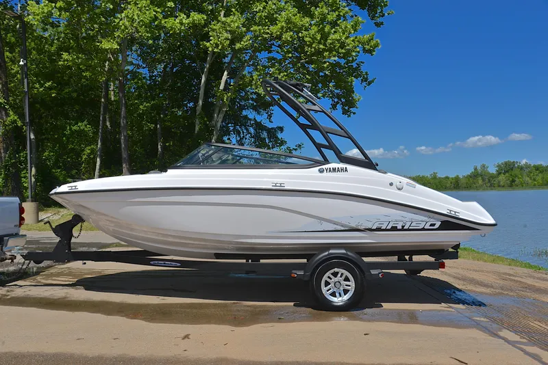 Slide: The Image of 2023 Yamaha Boats AR190 on trailer by a lake, surrounded by trees. - 11