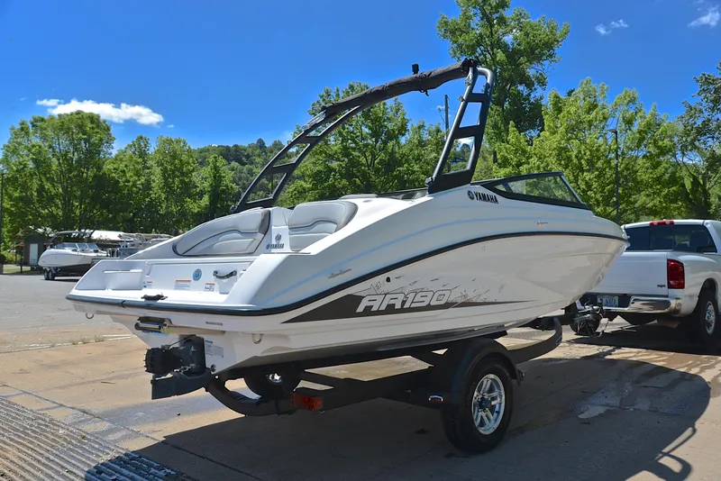Slide: The Image of 2023 Yamaha AR190 boat on trailer, parked outdoors under clear blue sky. - 14