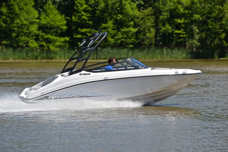 Slide: The Image of 2023 Yamaha AR190 boat cruising on a lake with lush green trees in the background. - 3