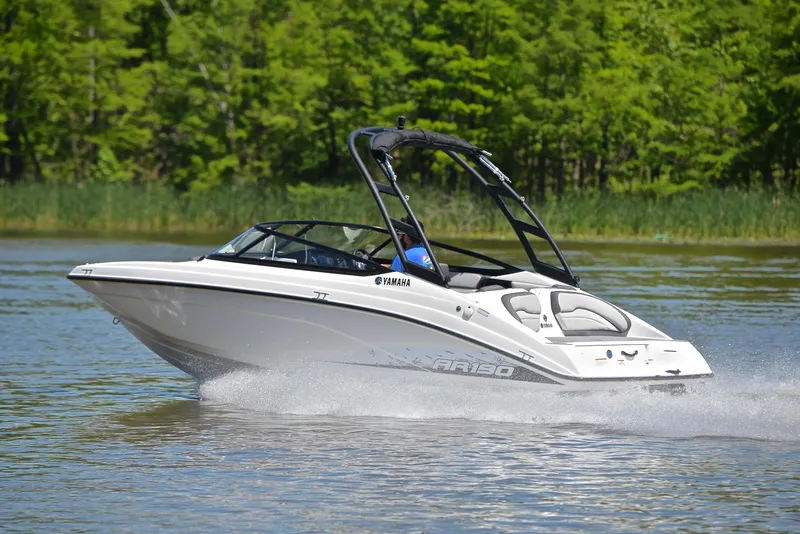 Slide: The Image of 2023 Yamaha AR190 boat cruising on a lake with lush green trees in the background. - 4