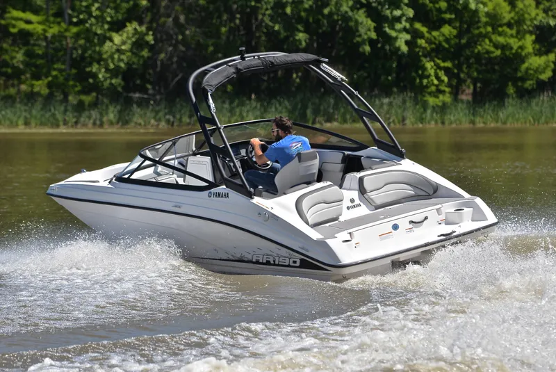 Slide: The Image of 2023 Yamaha AR190 boat cruising on a lake with lush green trees in the background. - 6