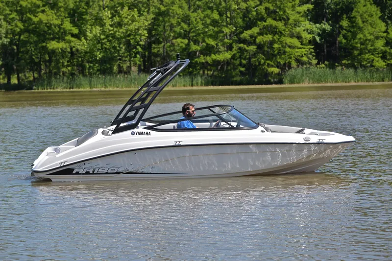 Slide: The Image of 2023 Yamaha AR190 boat cruising on a calm lake with lush green trees in the background. - 7