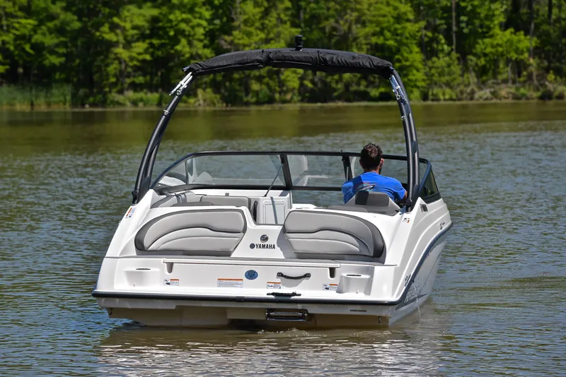 Slide: The Image of 2023 Yamaha AR190 boat cruising on a calm lake with lush green surroundings. - 8
