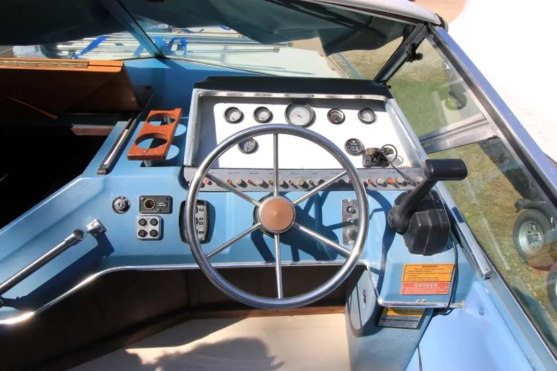 Slide: The Image of 1981 Sea Ray 245 SRV boat dashboard with steering wheel and control panel. - 11