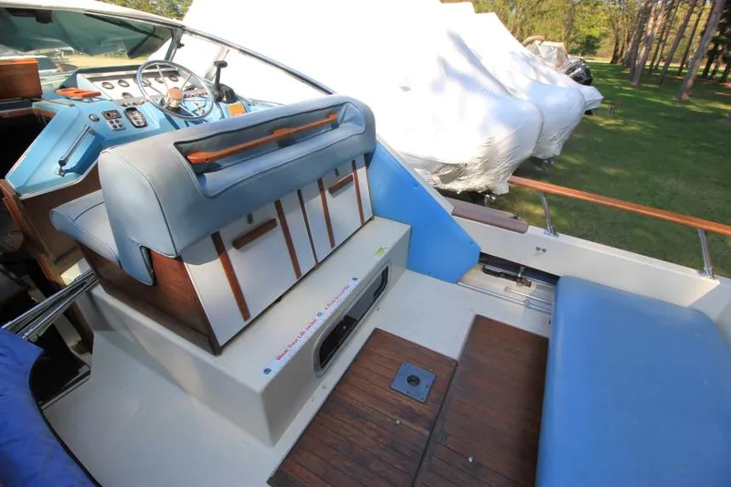 Slide: The Image of 1981 Sea Ray 245 SRV boat interior with blue seating and wooden accents. - 12