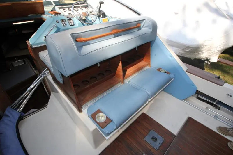 Slide: The Image of 1981 Sea Ray 245 SRV boat interior with blue seating and wooden accents. - 13