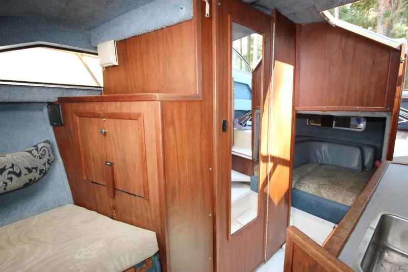 Slide: The Image of 1981 Sea Ray 245 SRV cabin interior with wood paneling and seating area. - 17