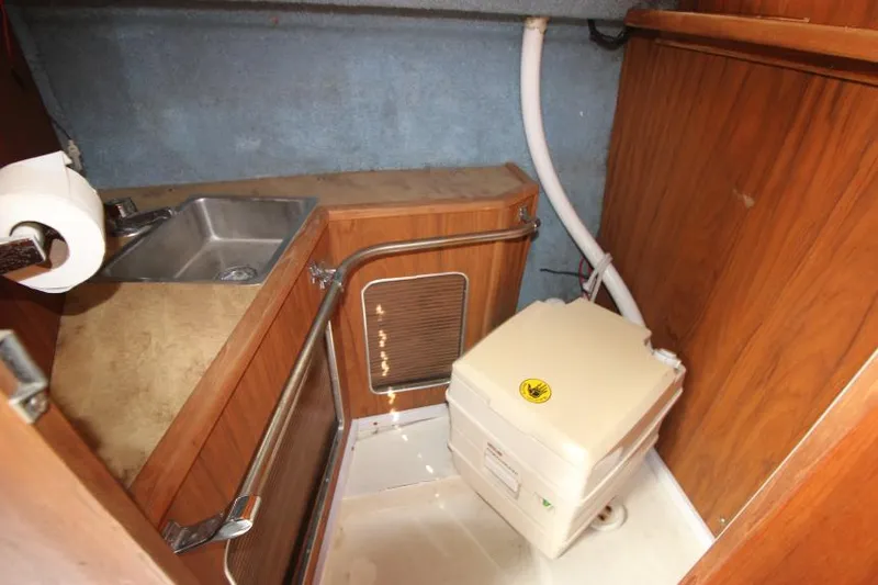 Slide: The Image of 1981 Sea Ray 245 SRV boat interior with sink and portable toilet. - 18