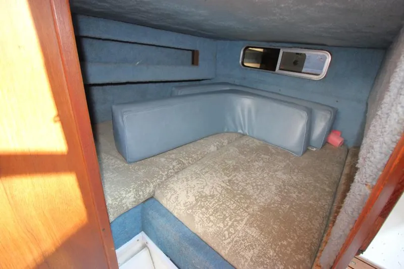 Slide: The Image of 1981 Sea Ray 245 SRV cabin interior with blue upholstery and window. - 19
