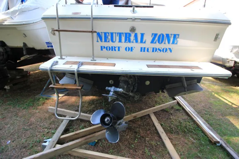 Slide: The Image of 1981 Sea Ray 245 SRV boat with "Neutral Zone" text, docked on wooden supports. - 6