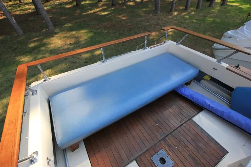 Slide: The Image of 1981 Sea Ray 245 SRV boat deck with blue cushion and wooden flooring. - 7