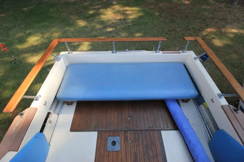 Slide: The Image of 1981 Sea Ray 245 SRV boat interior with blue seating and wooden deck. - 8