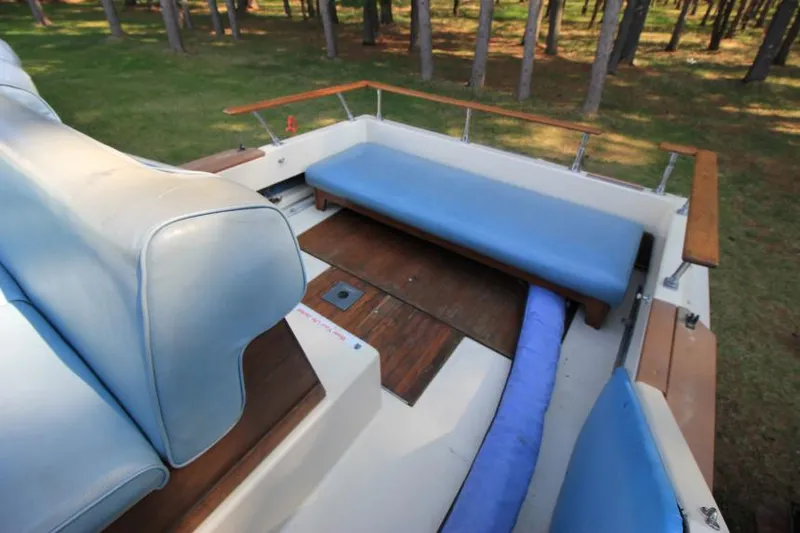 Slide: The Image of 1981 Sea Ray 245 SRV boat interior with blue seating and wooden deck. - 9