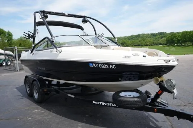 Slide: The Image of 2016 Stingray 208LR boat on trailer, parked outdoors with scenic background. - 3