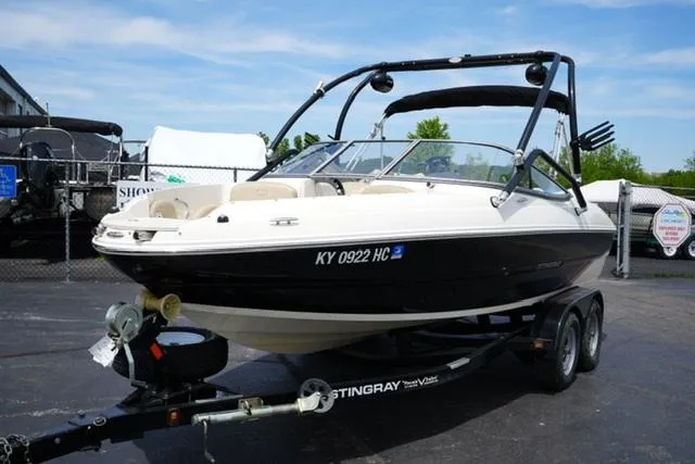 Slide: The Image of 2016 Stingray 208LR boat on trailer, parked outdoors, sunny day. - 5