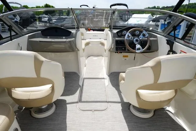 Slide: The Image of 2016 Stingray 208LR boat interior with beige seating and modern dashboard. - 7