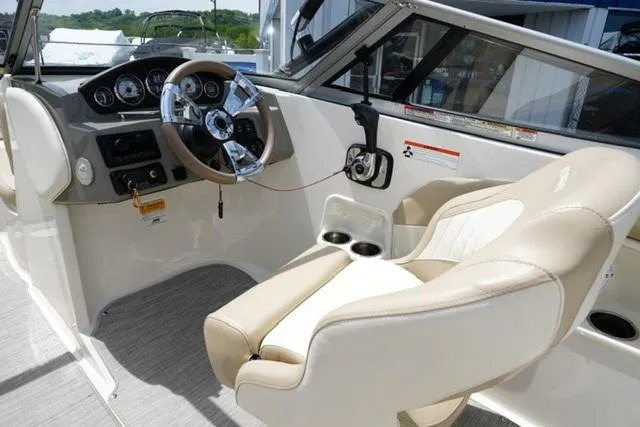Slide: The Image of 2016 Stingray 208LR boat interior with beige seating and steering wheel. - 8