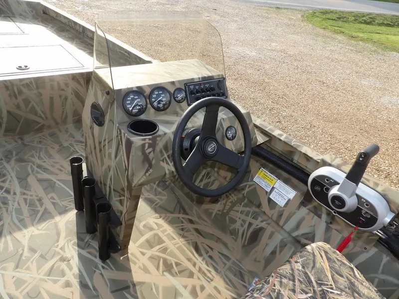 Slide: The Image of 2025 Crestliner 2070 Retriever SCHD boat interior with camouflage design and steering console. - 15
