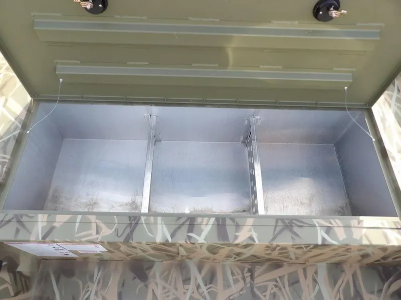 Slide: The Image of Open storage compartment in 2025 Crestliner 2070 Retriever SCHD boat, featuring camouflage design. - 23